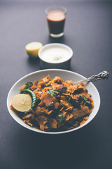 Homemade Kothu Parotta/ Paratha or Stir Fried Leftover Chapati Masala or  fodnichi poli in marathi, served in a bowl or plate with curd and hot tea. Selective focus