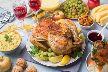 Baked chicken, mashed potatoes and wine glasses for dinner on the festive table.