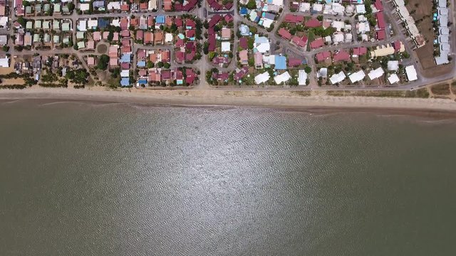 Vertical drone shot of the ocean and front beach neighbourhood Guiana