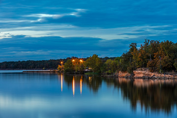 Naklejka na ściany i meble Long exposure of lights reflecting in the water at a lake.