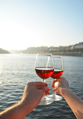 Wine glasses in the hands against Douro river in Porto, Portugal