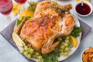Baked chicken, mashed potatoes and wine glasses for dinner on the festive table.