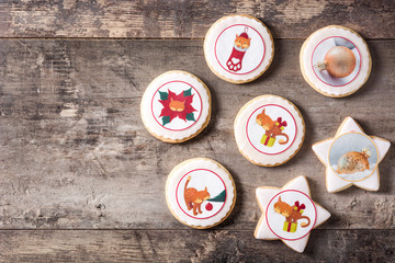 Christmas butter cookies decorated with Christmas graphics, on wooden table. Top view. Copyspace