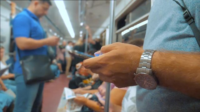 Casual man reading from mobile phone smartphone screen while looks the navigator traveling on lifestyle metro in the subway. slow motion video. Wireless internet on public transport concept. man in
