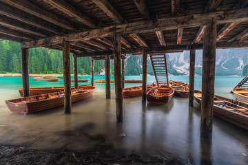 The boats under the pier at Lake Braies in Dolomites, Italy