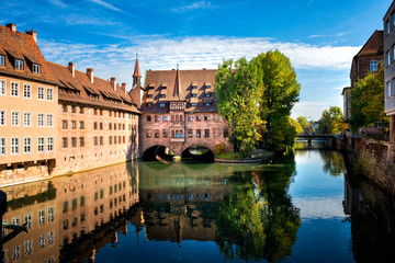 Nuremberg, Heilig-Geist-Spital which is reflected in the waters of the Pegnitz river. Franconia,...