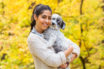Beautiful Smiling Woman Hugging  Her Cute Havanese Dog in the  Autumn Yellow Forest.Owner and Dog Happy Together 