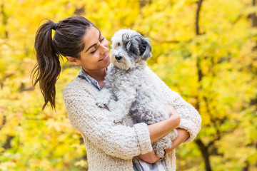 Beautiful Smiling Woman Hugging  Her Cute Havanese Dog in the  Autumn Yellow Forest.Owner and Dog Happy Together 