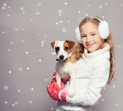 Girl with puppy in winter clothes