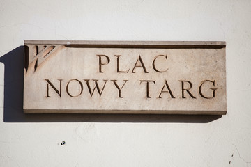 Clay plate with the inscription of the name of the square in Polish: Plaс Mowy Targ (Square New Targ)