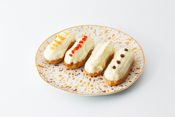 four eclair cakes on a white plate isolated on white background