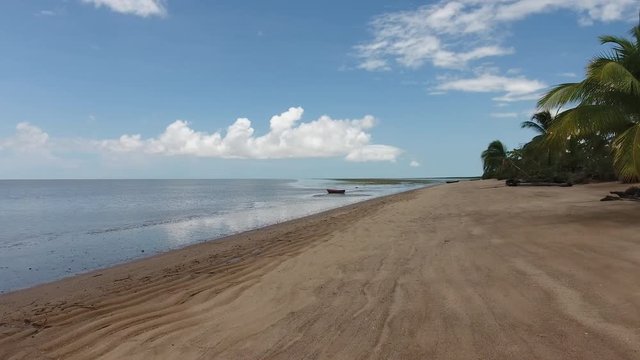 Flight towards a pirogue canoe on a beach in Awala Yalimapo village Guiana