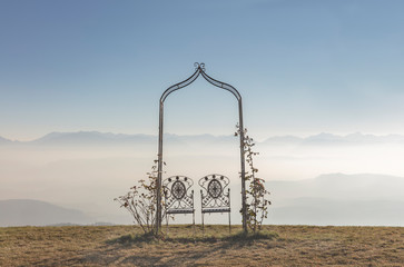Romantic seats for couple on top of the mountain with foggy landscape and mountains in the background
