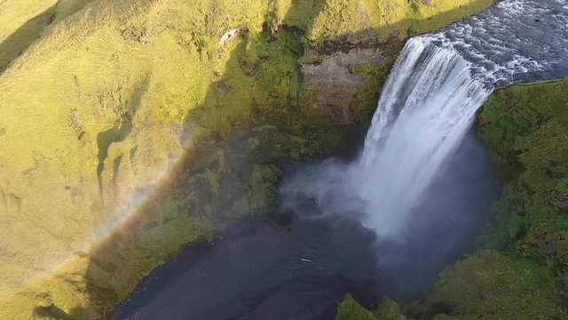 Aerial drone shot flying over the famous Skogafoss waterfall in Iceland. Rainbow sunny day. medium altitude flight