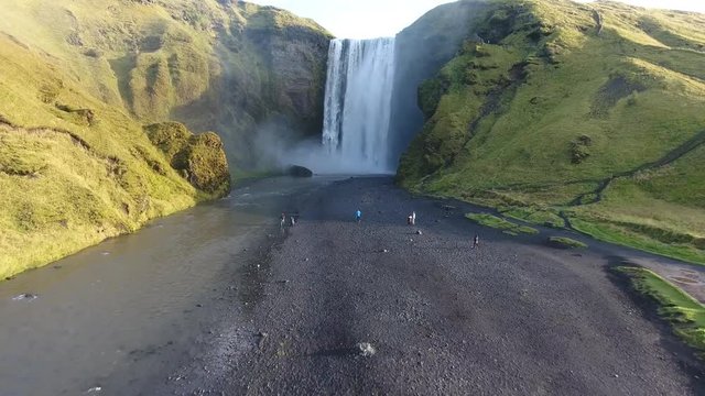 Aerial drone shot flying towards the famous Skogafoss waterfall in Iceland. Sunny day medium altitude flight
