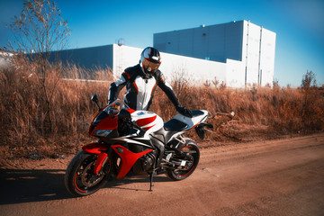 biker stands near the spott bike in the industrial area