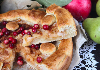 Apple pie with cranberries on a dark wooden background