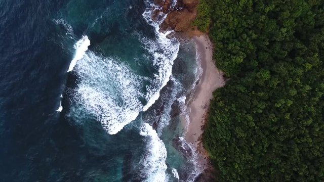 Aerial drone shot over coast waves in martinique 