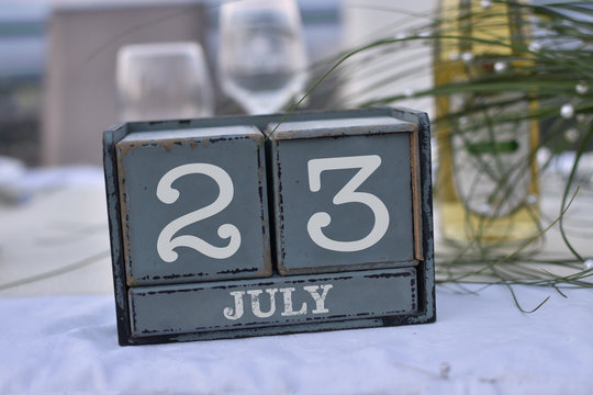 Wood blocks in box with date, day and month 23 July. Wooden blocks calendar
