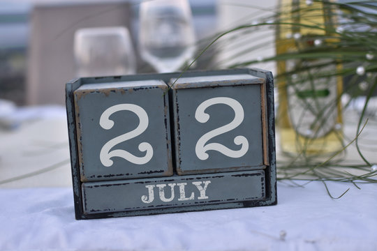 Wood blocks in box with date, day and month 22 July. Wooden blocks calendar