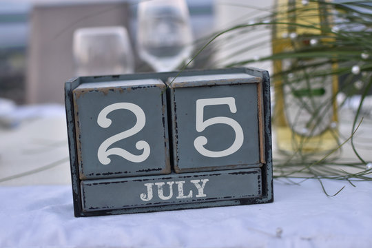 Wood blocks in box with date, day and month 25 July. Wooden blocks calendar