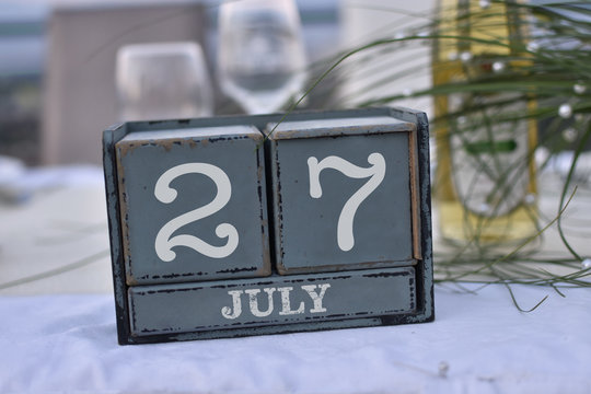 Wood blocks in box with date, day and month 27 July. Wooden blocks calendar