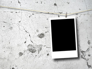 Single blank rectangular instant photo frame against cracked and weathered concrete wall background