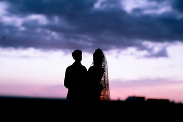 Silhouette of newlyweds with sunrise background