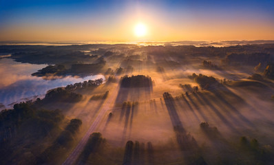 Aerial view of epic light rays over the fields at Autumn