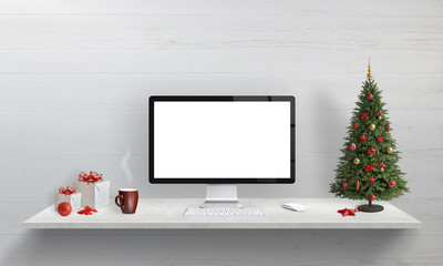 Computer display mockup on office desk with Christmas holiday decorations. Christmas tree and gifts beside.