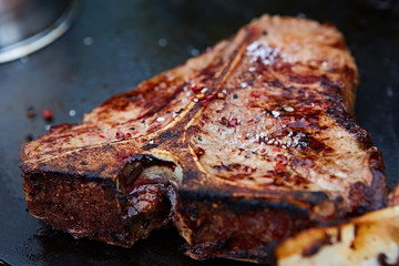 Grilled T-Bone Steak on serving board on wooden background