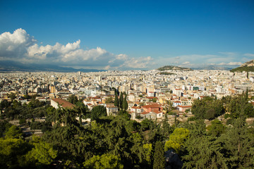 Naklejka premium Scenery landscape of Athens - capital of Greece with view on mountain, houses and horizon line with blue sky with clouds from top of hill