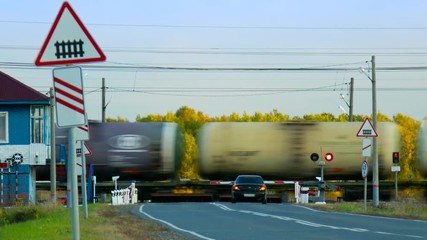 freight tanks train moves by railroad crossing at forest