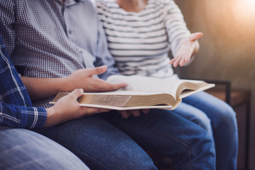 Christian friends group reading and study bible together in home or Sunday school at church with window light