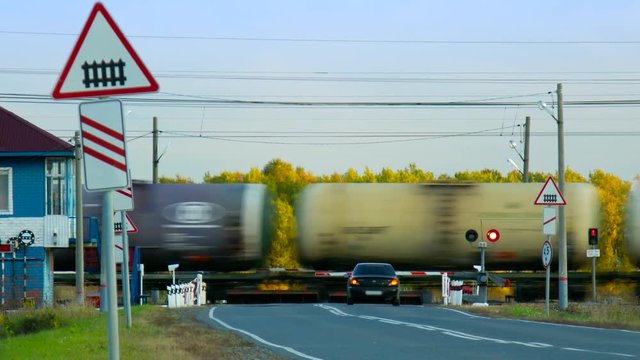 freight tanks train moves by railroad crossing at forest
