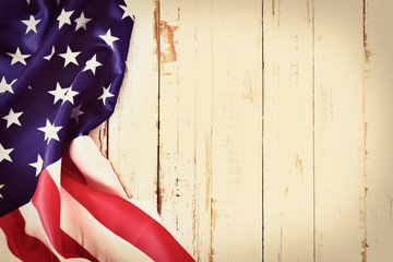 Close up of ruffled American flag over grunged wooden wall with a lot of copy space. Patriotic...