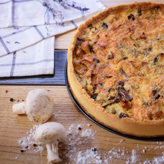 Tart with mushrooms and onion on the wooden table