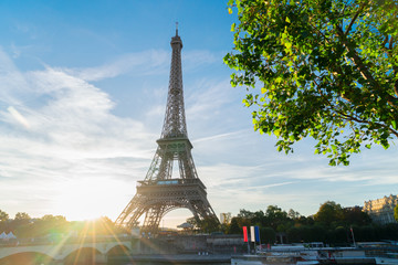 Eiffel Tower famous landmark with shining sun at sunrise, Paris, France