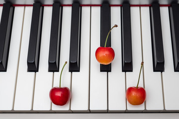 Piano chord shown by cherries on the key - A