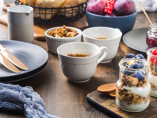 Cozy Breakfast concept on dark wooden textured background. Coffee and yogurt with home made granola