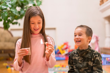 Small children playing with fire at home. A child plays with matches in the foreground a burning match, a child and matches, a fire, dangerous