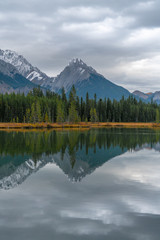 The foothills of the Rockies reflecting in an alpine lake in Canada