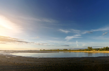 Beautiful sunset, sky with clouds above lake.