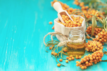 Natural, organic sea-buckthorn berry in linen bag and sea buckthorn oil in glass vintage bottle