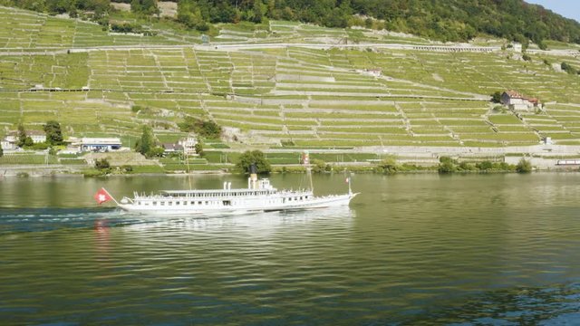 Aerial orbit around CGN Belle-Epoque steam boat on Lake L&radic;&copy;man in front of Lavaux, Swiss train passing along the shore