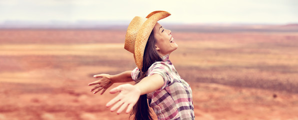 Cowgirl american woman happy with open arms in freedom wearing cowboy hat enjoying outback...