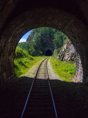 Fototapeta na wymiar Two old stone mountains railway tunnels on the Circum-Baikal railway on the shore of Baikal as a section of the Trans-Siberian Railway