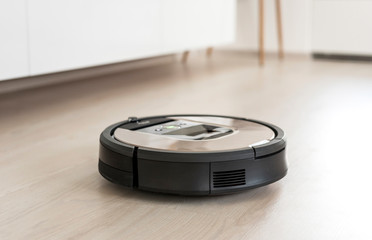 Fototapeta na wymiar Automated vacuum cleaning robot powered by rechargeable battery in modern living room