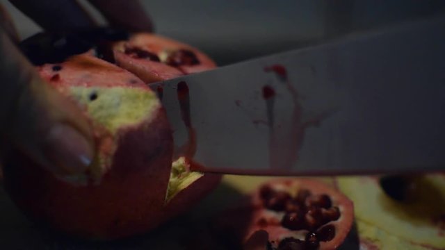 Cutting the juicy pomegranate close up.
Tagliando un melograno succoso ripresa da vicino.