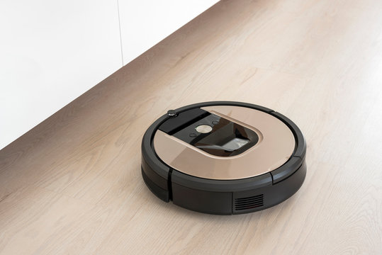 Automated vacuum cleaning robot powered by rechargeable battery in modern living room